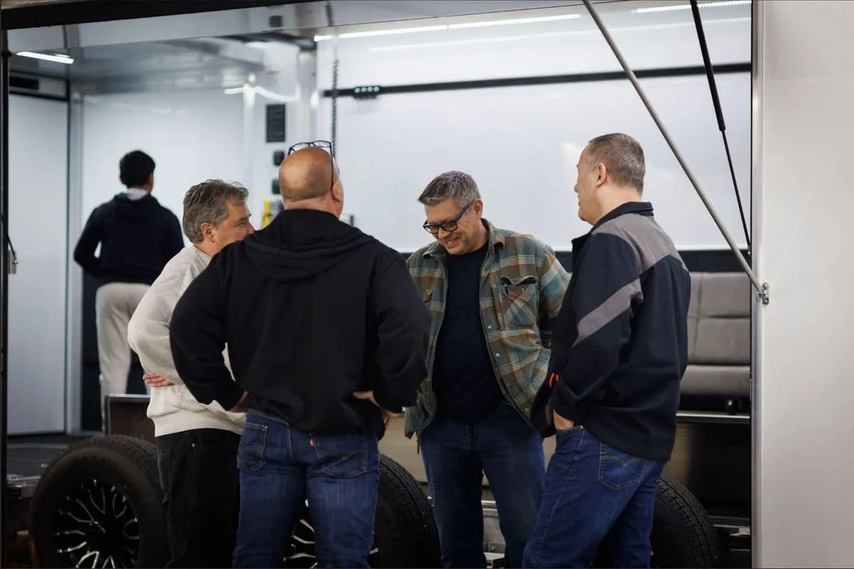 4 People standing in front of a trailer talking