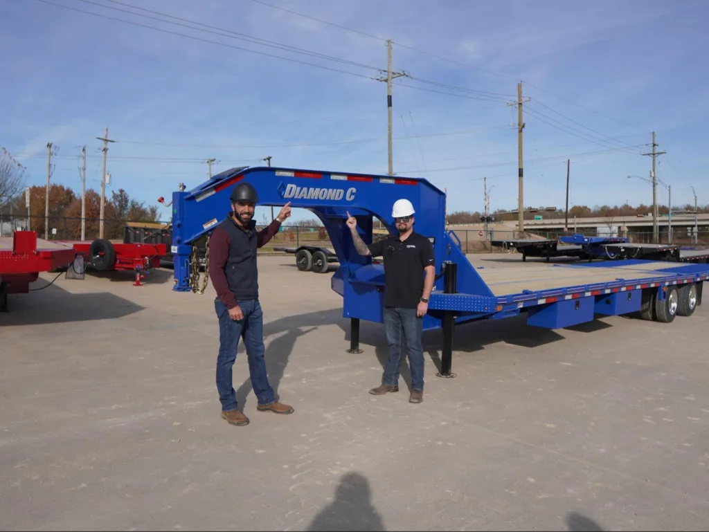 Diamond C Trailer Nerd Jacob Crabb with Sales Person in front of a Blue Diamond C Gooseneck Trailer