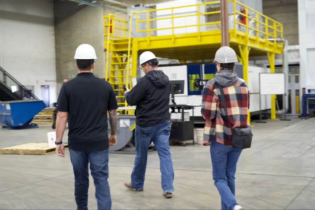 Three People walking through the Diamond C Manufacturing facility.